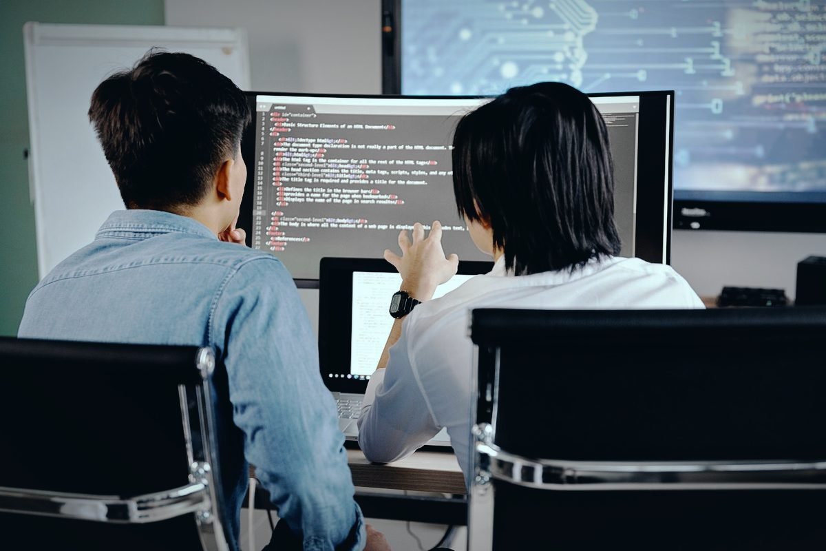 Dos personas revisando juntas el desarrollo de una aplicación en pantalla