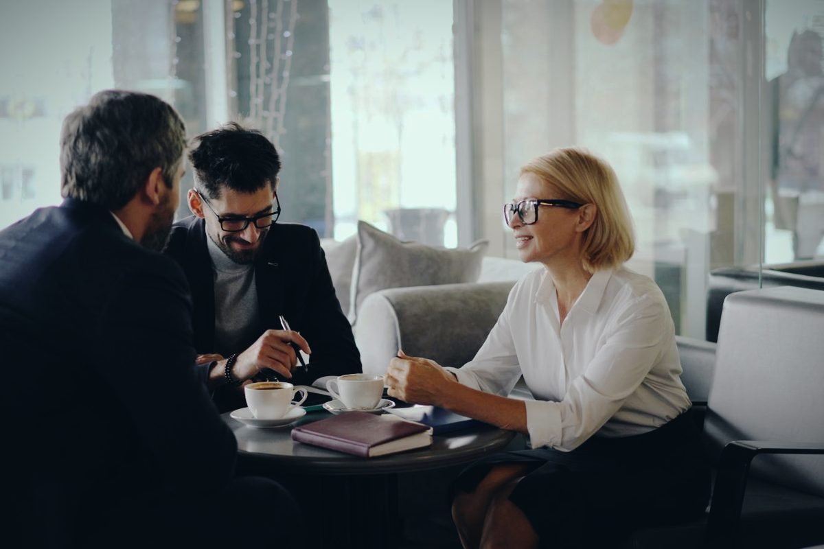 Tres profesionales conversando durante una reunión de consultoría