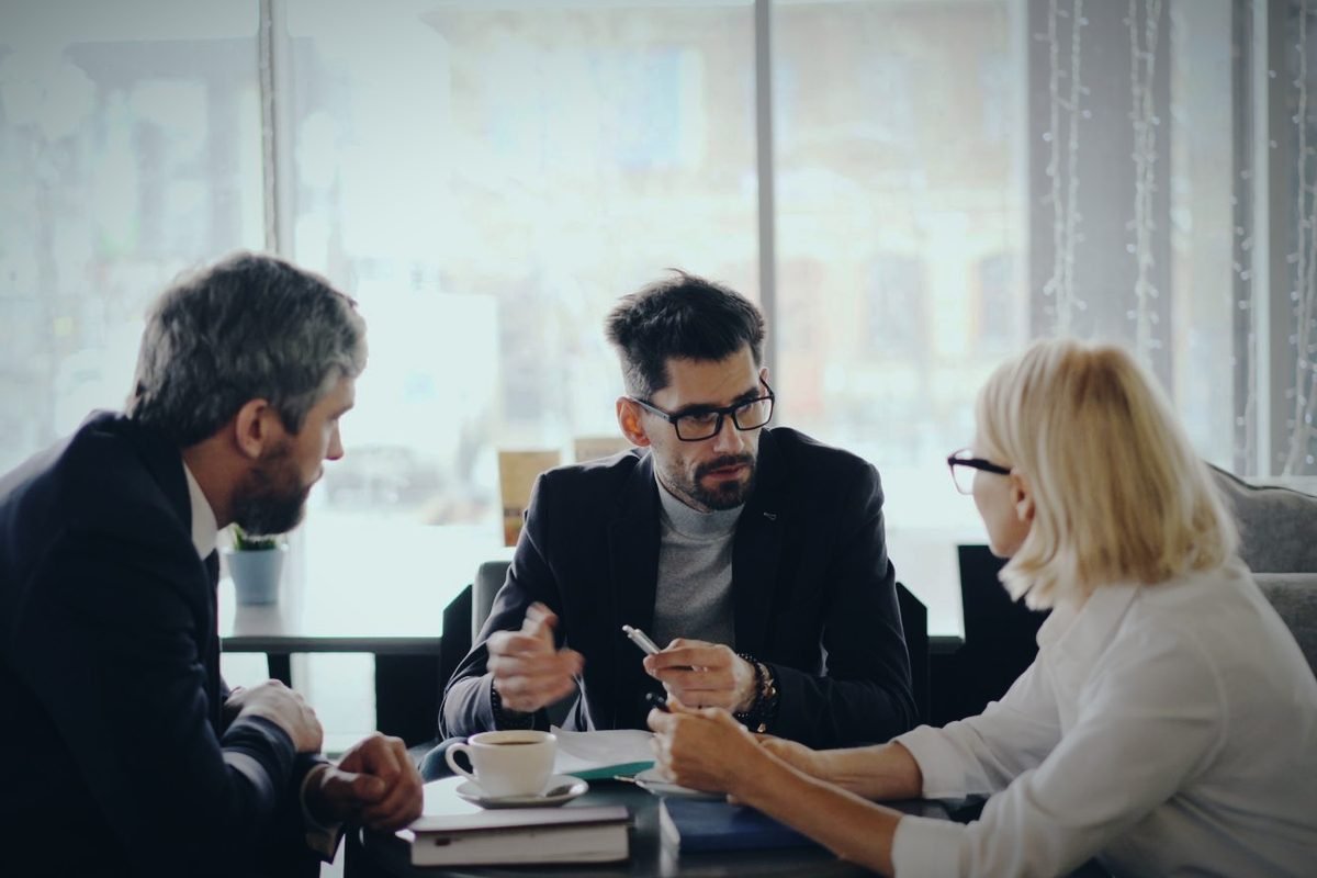 Equipo comercial en una reunión de trabajo junto a un ventanal