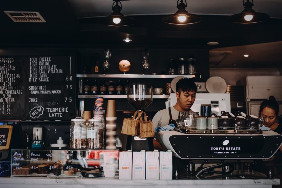 Baristas atendiendo el mostrador de una cafetería pequeña