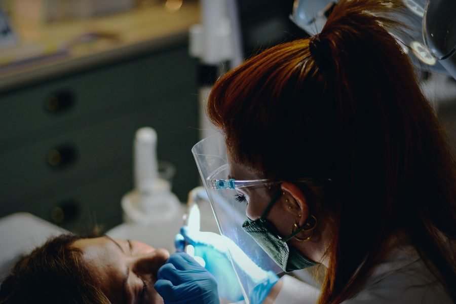 Dentista atendiendo a una paciente en el sillón