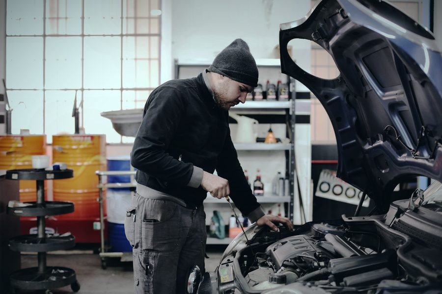 Mecánico trabajando sobre el motor de un coche en su taller